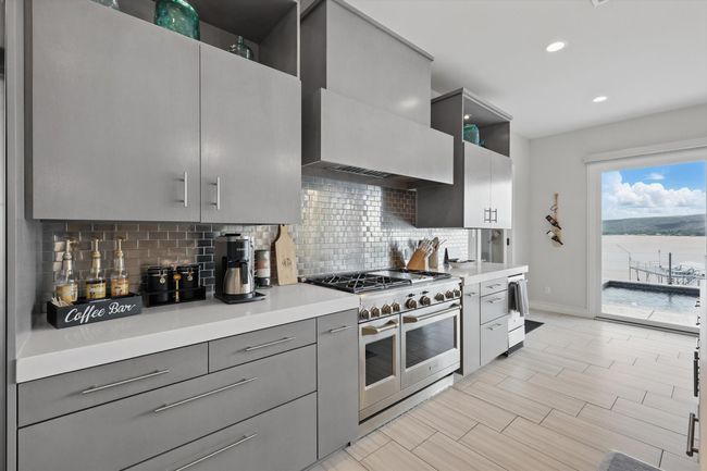 Kitchen with backsplash, range with two ovens, gray cabinetry, light countertops, and baseboards | Image 18