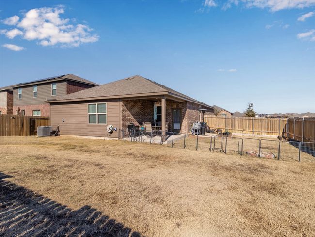 Rear view of property featuring cooling unit, a patio area, and a lawn | Image 27