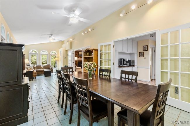 Dining room featuring light tile patterned flooring, a ceiling fan, and vaulted ceiling | Image 18