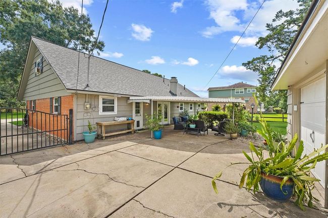 View of the home’s rear elevation featuring a spacious covered patio and lush backyard—perfect for outdoor living and entertaining. | Image 20