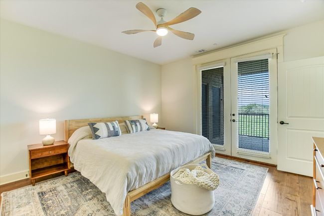 Primary Bedroom featuring access to exterior patio, wood finished floors, and ceiling fan. Views of distant hills and Lake Travis. | Image 12