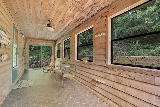 quiet sunroom off back of house has tiled floor with all new windows and Anderson doors on each end | Image 37