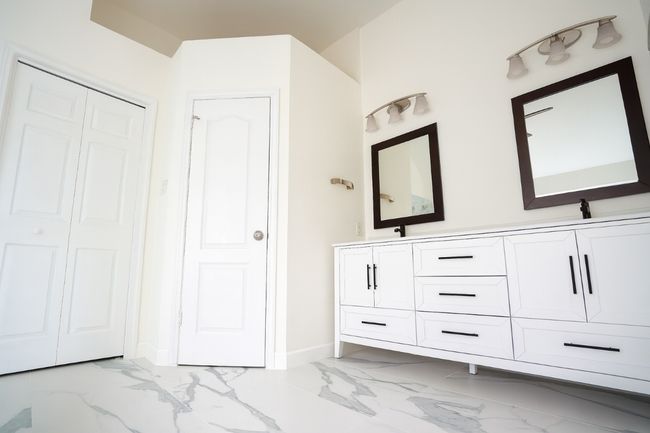 Full bathroom featuring a closet, double vanity, and light marble finish floors | Image 13
