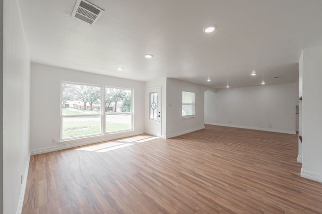 Unfurnished living room featuring baseboards, light wood-style flooring, and recessed lighting | Image 30