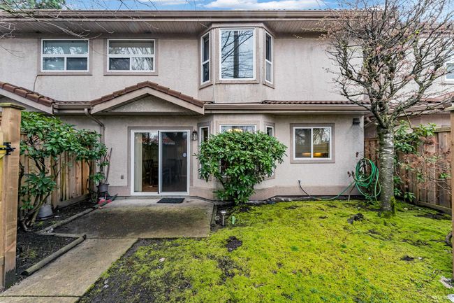 Back of property with a fenced backyard, a patio, a lawn, and stucco siding | Image 22