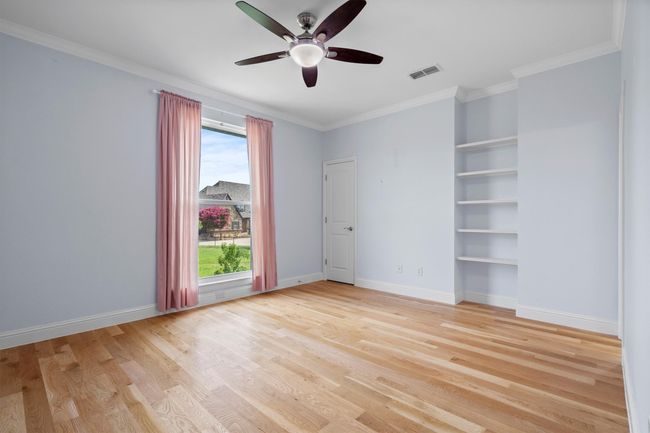 This charming guest room boasts beautiful wood floors, built-in shelving, large windows that brighten the space, and a generous closet! | Image 30