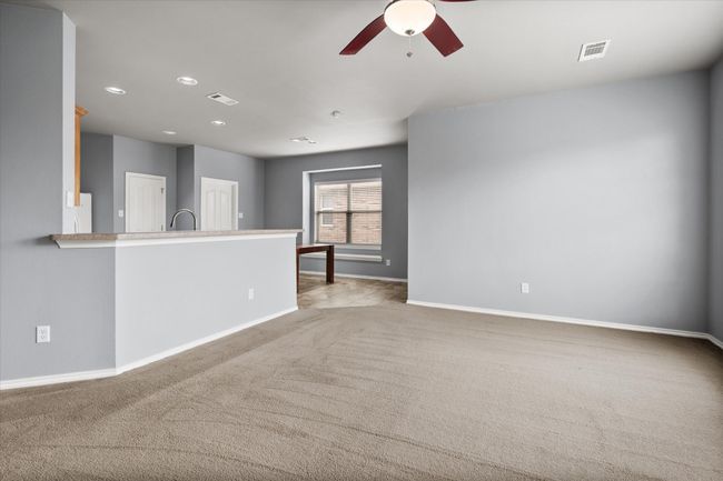 Empty room with a ceiling fan, carpet, and recessed lighting | Image 11