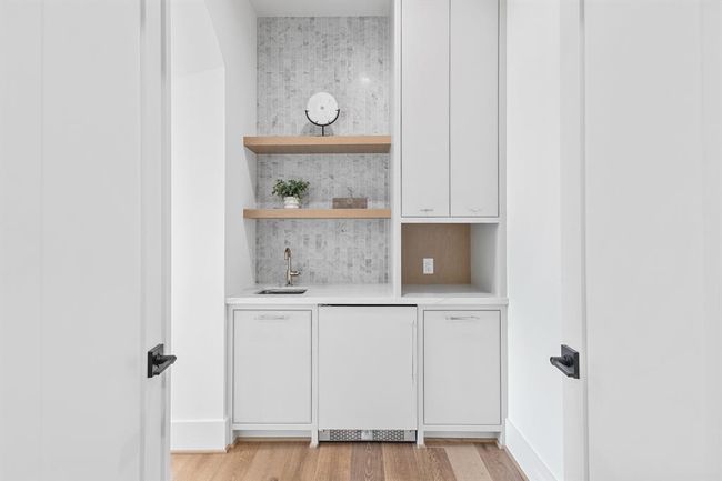 This private entryway to the primary suite is both functional and stylish, featuring a sleek wet bar and a mini fridge for ultimate convenience. | Image 36