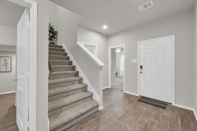 Just off the foyer you'll find your SECOND DOWNSTAIRS BEDROOM toward the front of the home which is right next to the FULL SIZED bathroom #2. On the other side of the stairs is where you'll find your laundry room + bonus storage space. | Image 5