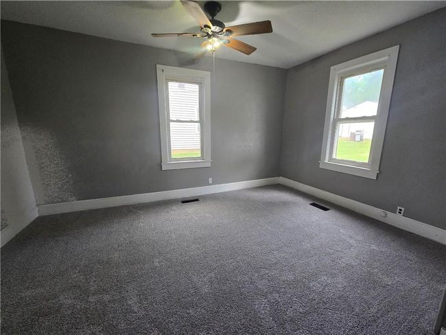 Carpeted empty room featuring plenty of natural light, ceiling fan, and baseboards | Image 19