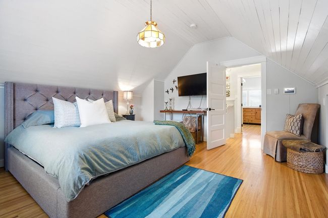 Bedroom with lofted ceiling and light wood finished floors | Image 18