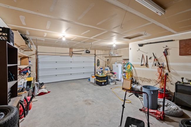 Garage featuring a garage door opener and freestanding refrigerator | Image 17