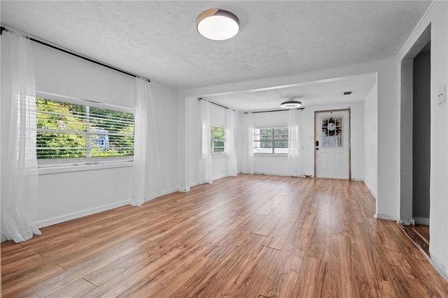 Empty room featuring wood finished floors and a textured ceiling | Image 6