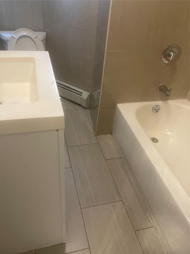 Bathroom with toilet, vanity, and a baseboard heating unit | Image 5
