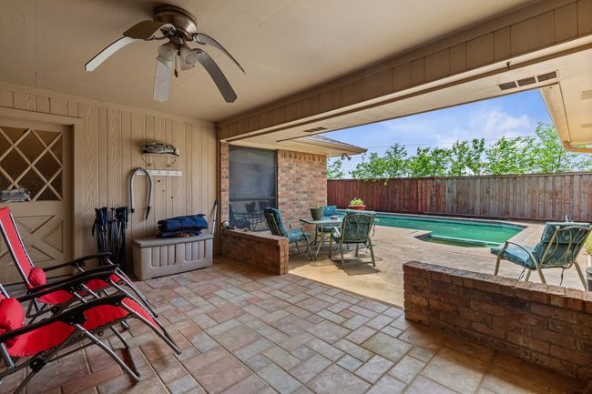 View of patio / terrace featuring a fenced backyard, a ceiling fan, a fenced in pool, and outdoor dining space | Image 31