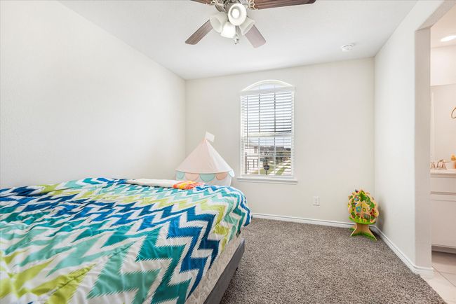 Bedroom featuring baseboards, a ceiling fan, connected bathroom, carpet flooring, and a sink | Image 19