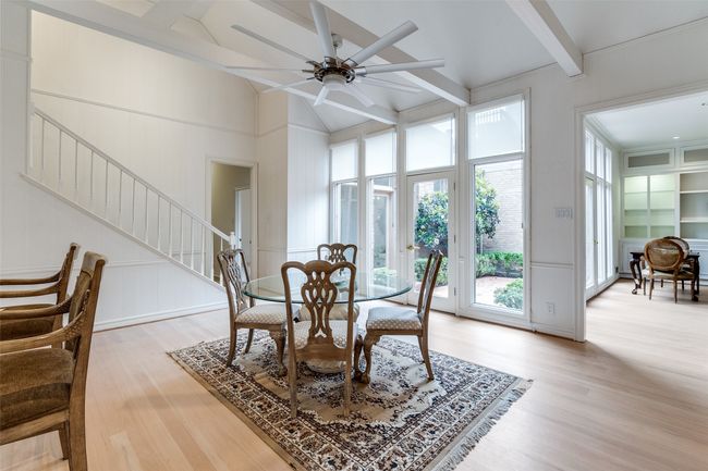 Dining area featuring light wood finished floors, a decorative wall, stairs, and ceiling fan | Image 11