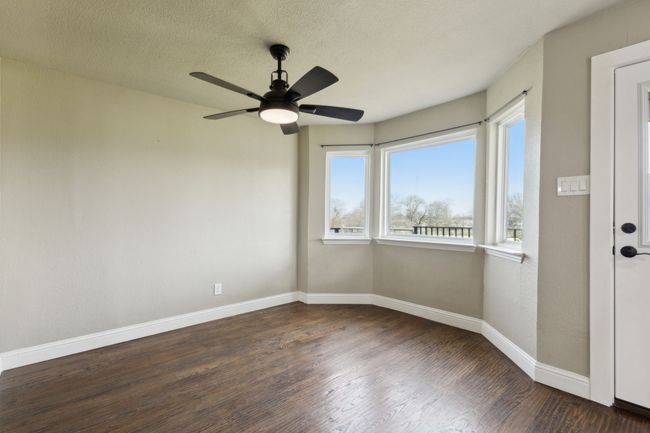 Spare room with ceiling fan, a textured ceiling, baseboards, and wood finished floors | Image 14
