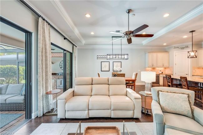Living room featuring ceiling fan, a tray ceiling, recessed lighting, and ornamental molding | Image 12