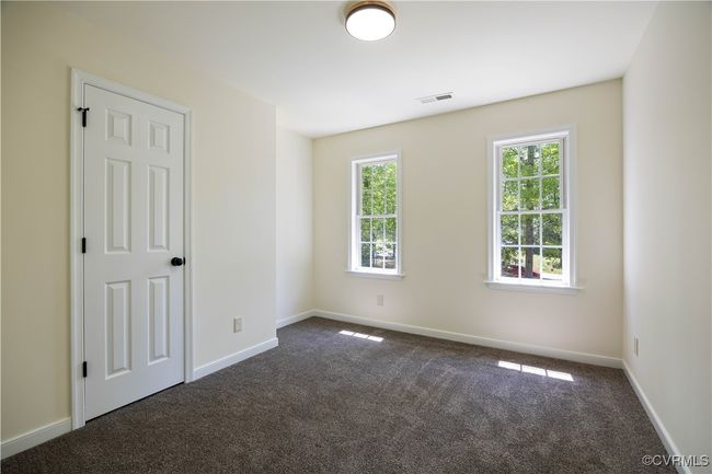 Empty room with baseboards, dark colored carpet, and visible vents | Image 20