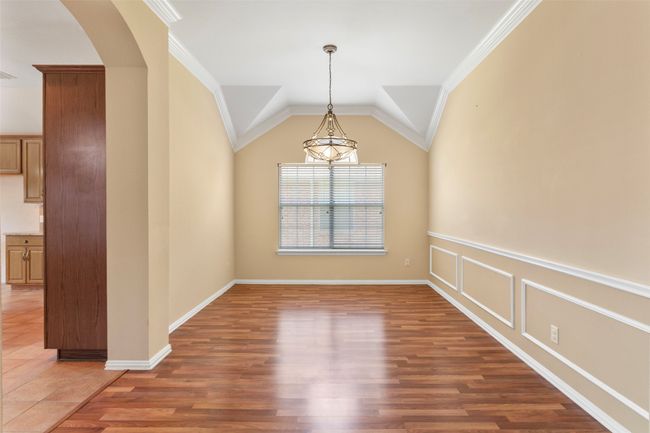 Spare room with arched walkways, wood finished floors, ornamental molding, and baseboards | Image 24