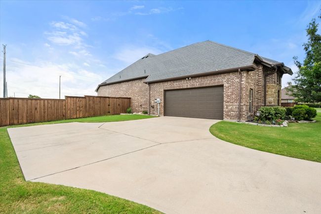 View of side entry garage with, concrete driveway | Image 7