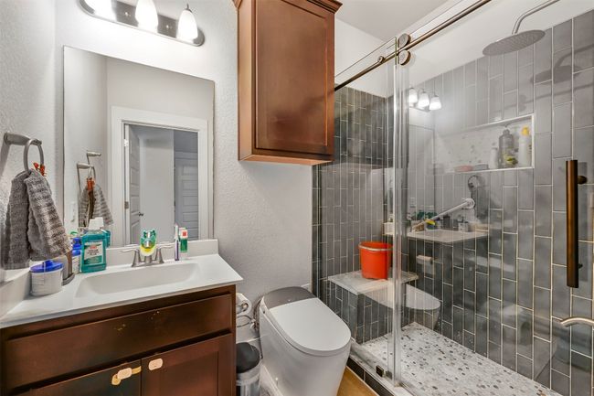 Bathroom with vanity, a shower stall, and a textured wall | Image 26