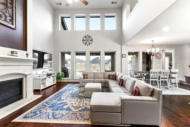 As you step into the grand living room, you'll be captivated by the dramatic floor-to-ceiling windows, offering stunning views of the pool and backyard. With eight windows in total, this room is flooded with natural light, creating a bright and airy atmosphere. The high ceilings enhance the open, spacious feel, while a wall of gorgeous windows serves as a striking focal point, seamlessly connecting the indoors with the outdoor oasis. | Image 13