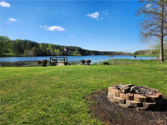 View of water feature featuring a fire pit and a view of trees | Image 24