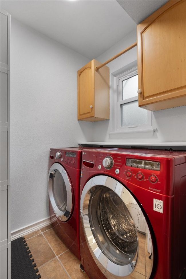 Laundry area with cabinet space, washing machine and clothes dryer, and tile patterned flooring | Image 17
