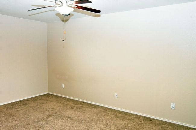 Carpeted empty room with a ceiling fan and baseboards | Image 13