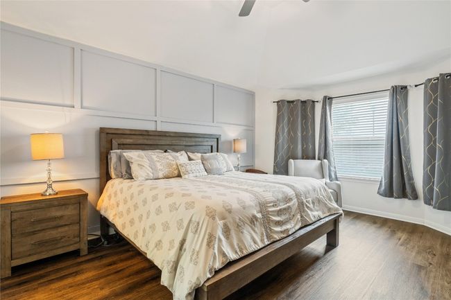 Bedroom featuring dark wood-type flooring, a decorative wall, and ceiling fan | Image 16