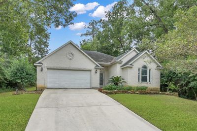 Alluring, single-story gem featuring a spacious two-car garage, set amidst lush mature trees in a tranquil neighborhood. The meticulously manicured lawn adds a touch of elegance to this idyllic retreat. | Image 2