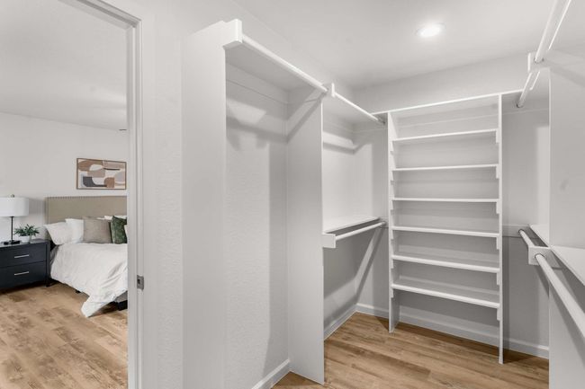 Spacious walk in closet with light wood-style floors | Image 14