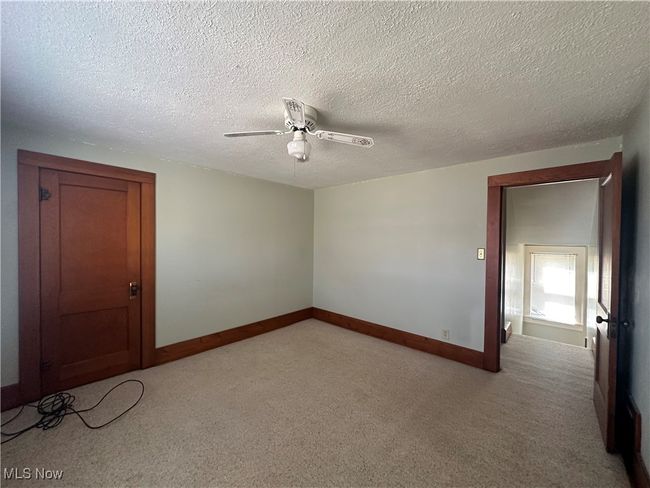 Unfurnished room with baseboards, a textured ceiling, a ceiling fan, and light colored carpet | Image 12