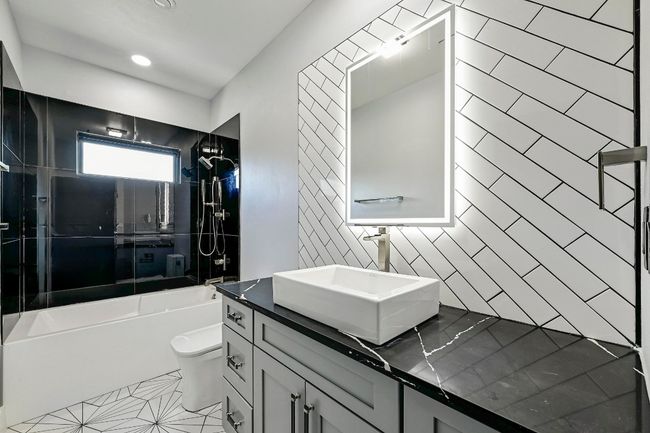 This full secondary bathroom is located upstairs and comes with designer finishes and a shower/tub combo with gorgeous tile backsplash. | Image 33
