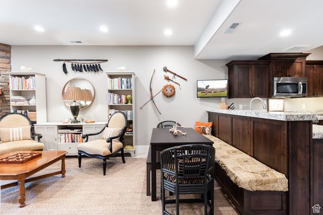 Interior space featuring visible vents, light colored carpet, dark brown cabinets, stainless steel microwave, and recessed lighting | Image 9