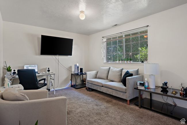 Carpeted living room with a textured ceiling | Image 34