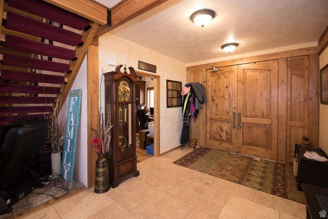 Entrance foyer with a textured ceiling and stairway | Image 59