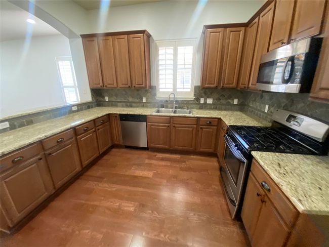 Large open gourmet style kitchen with updated stainless appliances and gas cooking. | Image 8