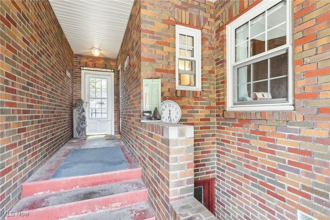 Property entrance featuring brick siding and covered porch | Image 27