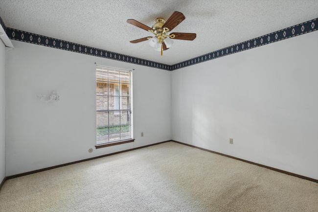 Spare room featuring carpet, a textured ceiling, baseboards, and ceiling fan | Image 29
