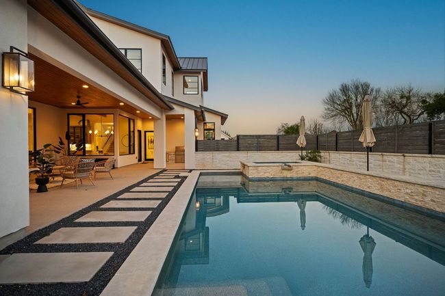 Pool at dusk with a patio area, a fenced backyard, and a fenced in pool | Image 32