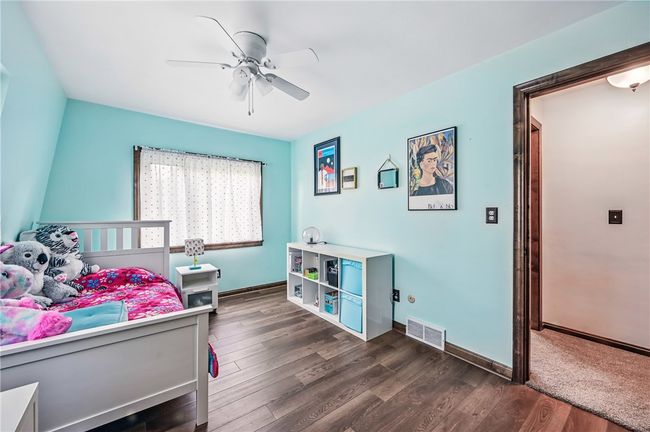 2nd floor bed #2: Cheerful bedroom with light blue walls and wood-look flooring. | Image 30