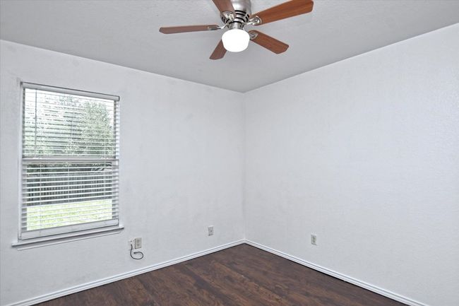 Unfurnished room with wood finished floors, baseboards, and a ceiling fan | Image 19