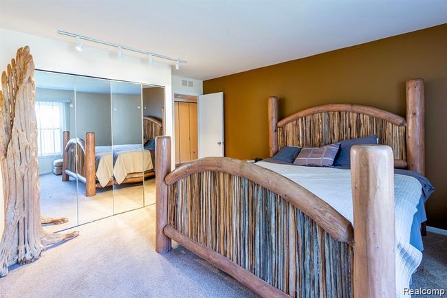 Carpeted bedroom with rail lighting and a closet | Image 22