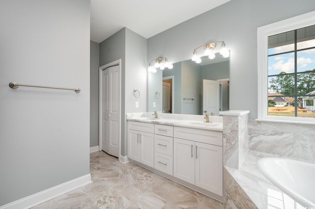 Bathroom featuring plenty of natural light, vanity, and tiled bath | Image 20