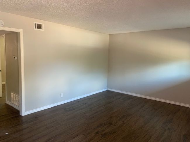 Unfurnished room with dark wood-style flooring, baseboards, and a textured ceiling | Image 5
