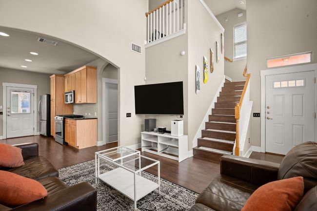 Living room featuring dark wood-type flooring, stairway, arched walkways, and visible vents | Image 5