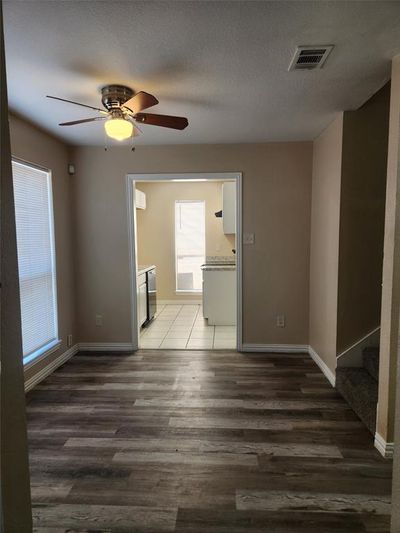 Unfurnished room with ceiling fan, a textured ceiling, and dark wood-type flooring | Image 3